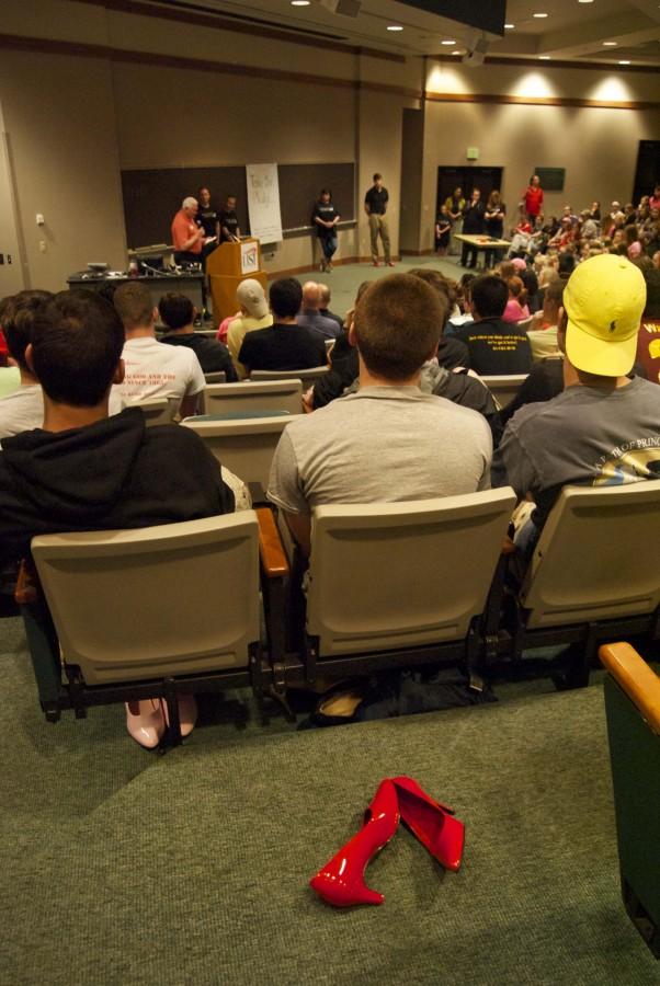 Students listen to a presentation in Mitchell Auditorium before donning colorful high heels and traipsing around campus during last year’s Walk a Mile in Her Shoes.