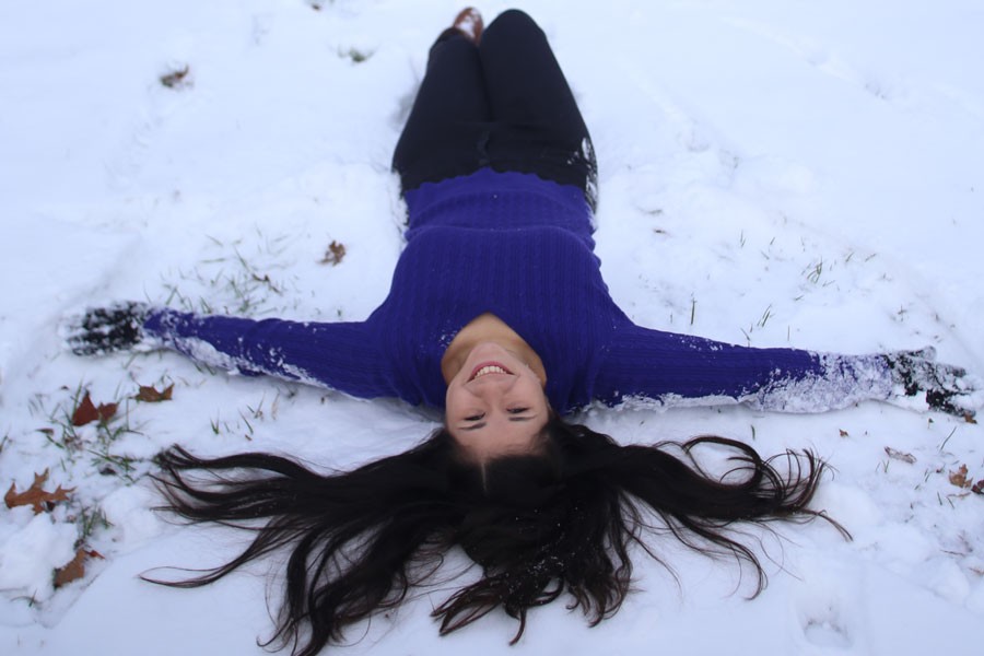 Junior international studies major Sandrita Sanabria makes a snow angel for the first time in her life in the Quad on Thursday. Sanabrita is from Paraguay, so the recent winter weather has been her first experience with snow. 