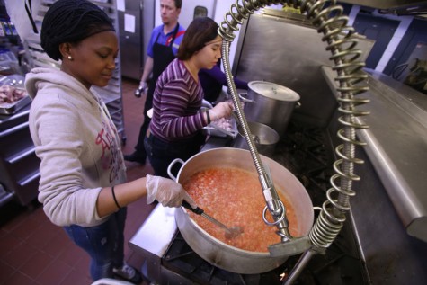 Mpho Mashabe (left), a graduate student studying public administration, stirs ingredients for the dish, jollof rice, that will be representing Ghana as Kow Pik Yok (right), a freshman English teaching major, prepares her food, bak kut teh, for Malaysia Thursday in The Loft’s kitchen. Both dishes will be served at the International Food Expo Friday in Carter Hall.