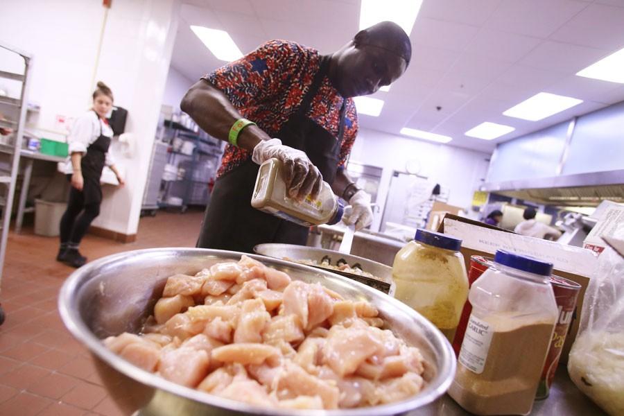 Shadrach Mensah, a graduate student studying public administration, adds spices to the dish, jollof rice, which will be representing Ghana for the International Food Expo Friday in Carter Hall. 
