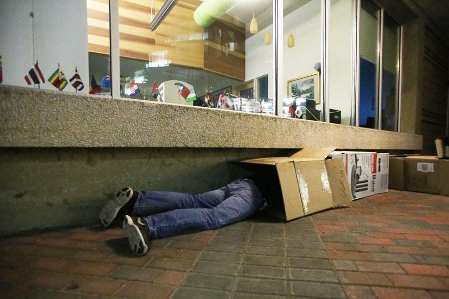 Seth Kidwell, a sophomore social work major, nestles into his newly constructed box home for the night Saturday outside of UC East. Kidwell was among 20 others who participated in Box Out of Boxville, an event organized to spread homelessness awareness by having students sleep in boxes overnight. 
