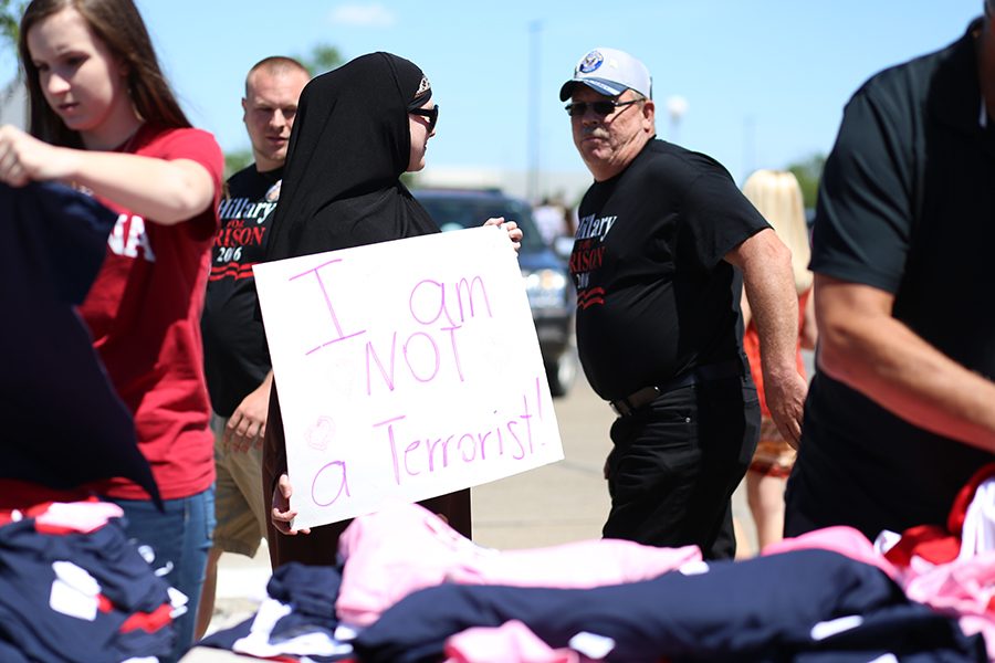 Jasmine Johnson, a Muslim protestor, holds a sign that reads “I am NOT a Terrorist!” as a Trump supporter walks by and asks “If that’s true, then why are you worried about it?” Thursday after the Trump rally finished. Johnson said there were a handful of Trump supporters who don’t believe all Muslims are terrorists, but overall she witnessed a lot of hate.