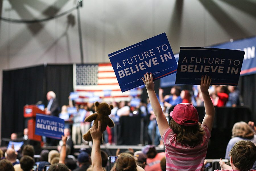 A child holds up two signs that read “A Future to Believe In” as many others lifted up their signs in agreement with Sanders during the rally Monday in the Old National Events Plaza.