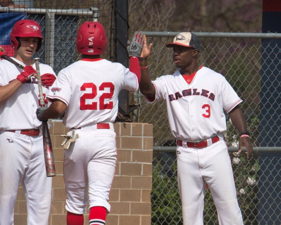 Senior Jaylen Quarles gives teammate Buddy Johnson a high-five after he walks off the field. 