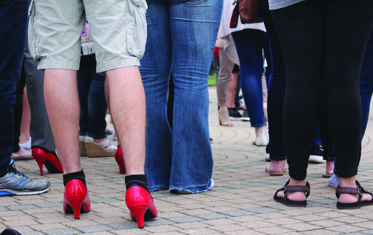 After speeches about sexual assualt and gender violence, male audience members walked a mile in bright red high-heels to raise awareness for violence against women and men during the 11th annual “Walk a Mile in Her Shoes” Tuesday evening. Students, professors and community members walked from the UC, past the Orr Center and ended at the College of Liberal Arts, where members of the community, officers and Dean Beeby spoke about their experience walking in the heels, before the participants took a pledge to never “commit, condone or remain silent about violence against women.”
