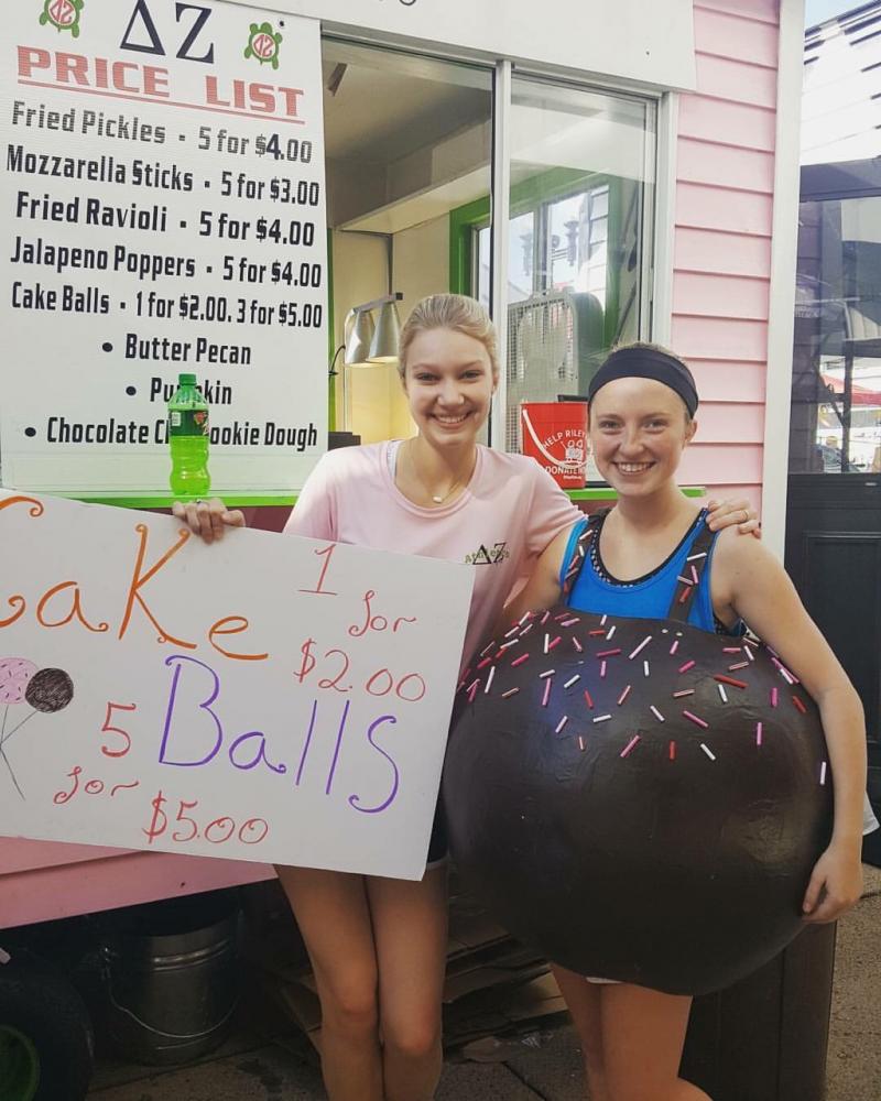 Members of Delta Zeta stand in front of their booth, the only pink painted booth at Fall Fest. The university Greek Life are just a few of the organizations that participate in the popular Evansville event.  