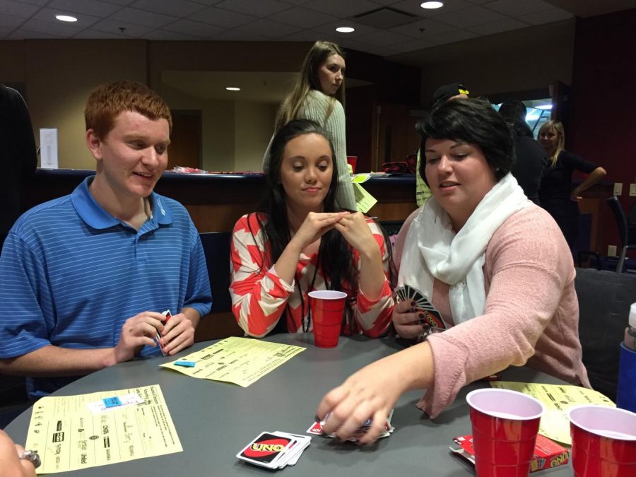 Marcus Gribbins (left) sophomore communication studies major, Hannah Holte (center) senior elementary and special education major, and Nicole Schwartz (right) a recruiter from T.J.Maxx played a challenging game of Uno at the networking game night Wednesday evening.