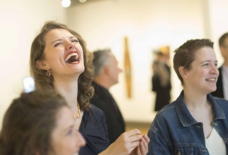 Sarah Feagan, a senior studio art major, laughs with friends during the Senior Seminar Exhibition Sunday afternoon. Feagan had two pieces accepted into the show. 