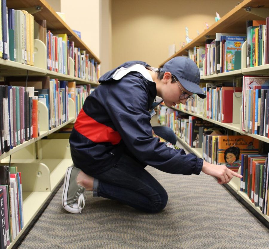 Holland Davis places books back where they belong at David L. Rice Library where she works part-time. 