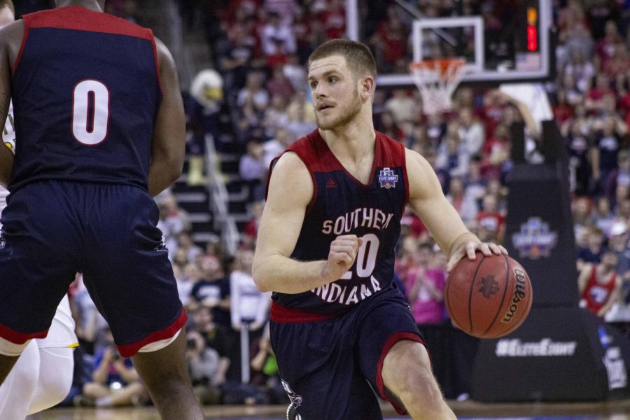 Running around a member of the opposing team, senior guard Alex Stein looks for an open teammate.