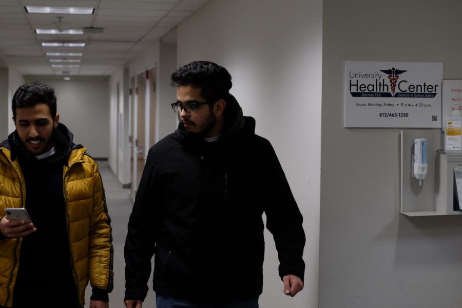 Ateg Alharthei, senior health administration major (left) and Zaid Altayyar, senior public health major (right), walks past the University Health Center.