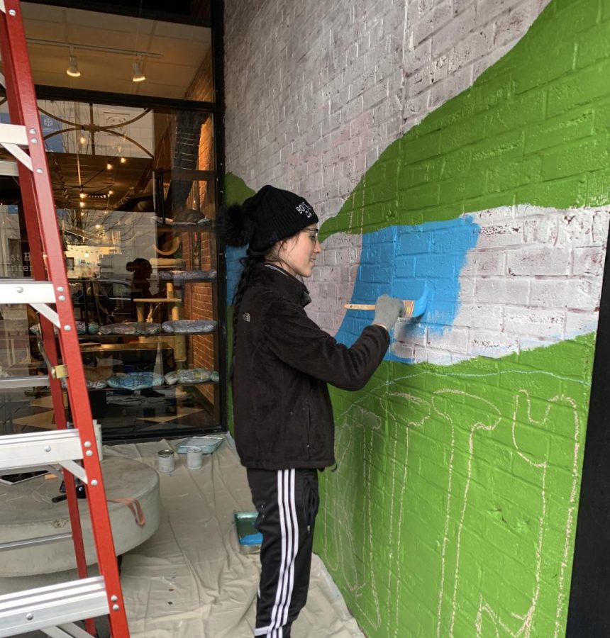 Jenna Sharp, USI graduate and recipient of the Endeavor Award grant, paints a mural at the River Kitty Cat Cafe on Main Street.
