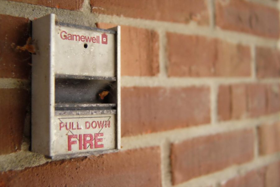 a fire alarm against a brick wall