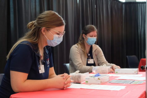 Nursing students Eleanor Conley and Maddison Fields prepare their vaccination stations Apr. 7. Conley said it was an honor to administer COVID vaccines to her fellow students. 