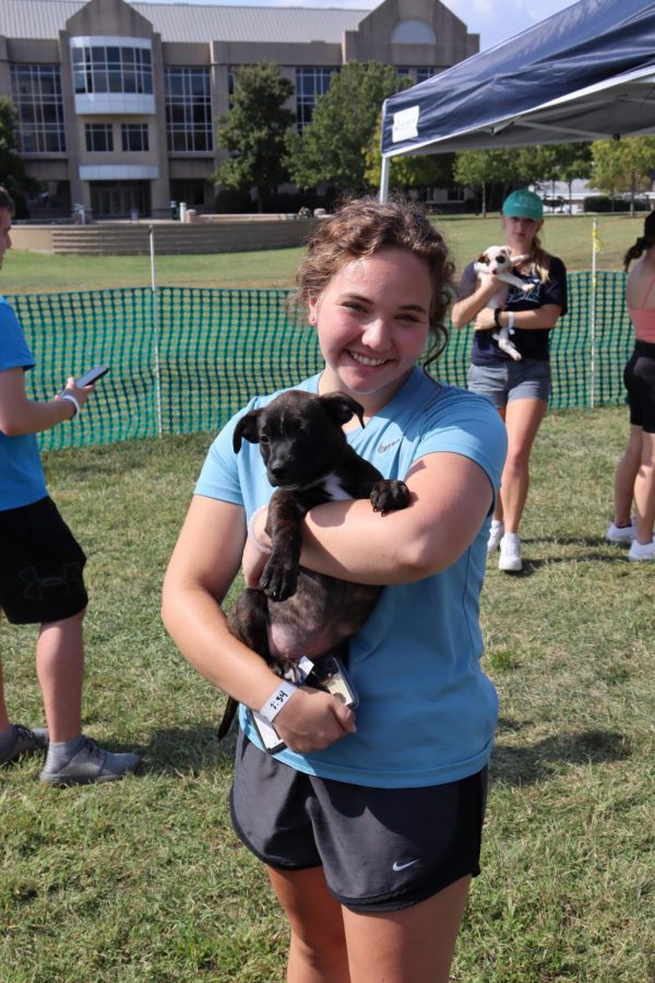 Morgan Dexter, a freshman public relations major, smiles widely as she holds a pup on Wednesday at Sigma Tau Gammas Pet-A-Pup event.