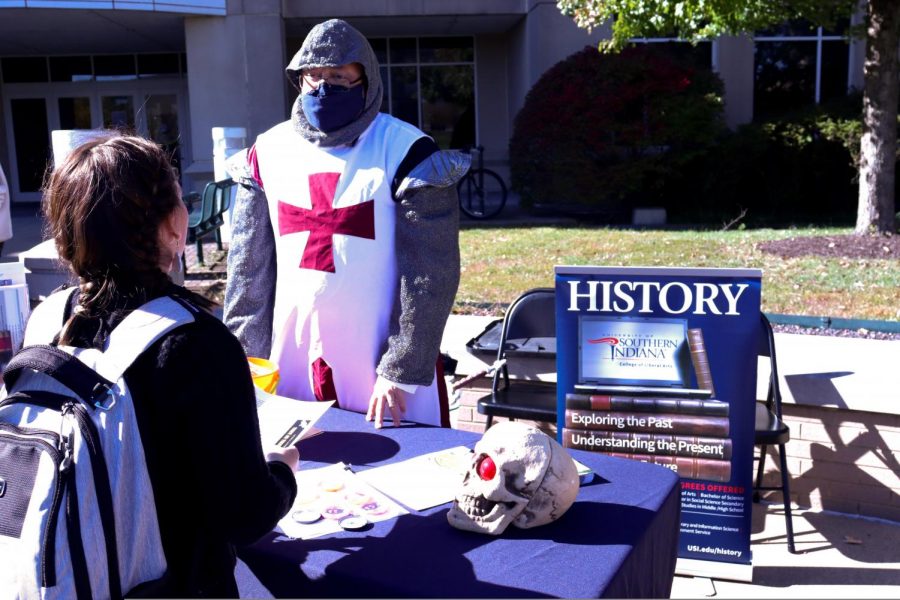 Jason Hardgrave, Chair of History Department, explains his passion for history to a student at his table Wednesday, dressed as a Templar knight. 