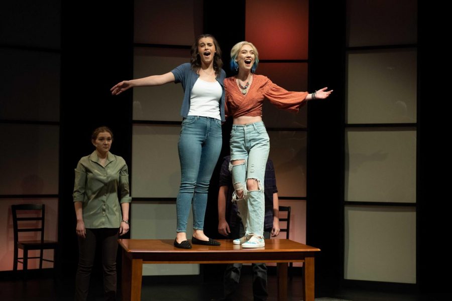Students perform The Mad Ones as part of USI Theatres Fall 2021 productions.  Samantha Brown (Evelyn Pigman) and Kelly (Clare McGregor) sing about their future in front of Sams mom Beverley (Grace Koltz) and Sams Boyfriend Adam (Nate Jenkins). 