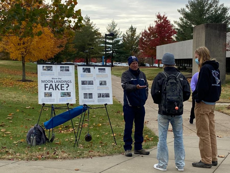 Peter Jarvio shows his model of the flat Earth to two students in the universitys Free Speech Zone on Monday. 