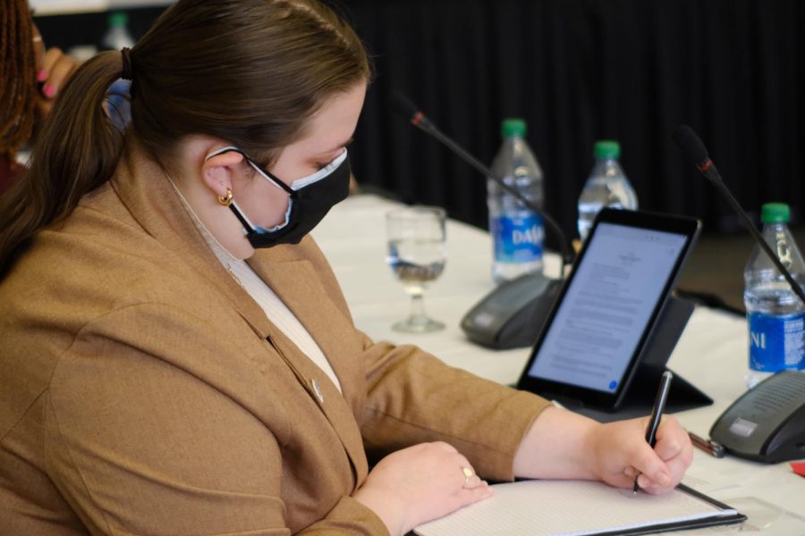 Anna Ardelean, student government association president, takes notes during the Board of Trustees meeting Thursday morning.