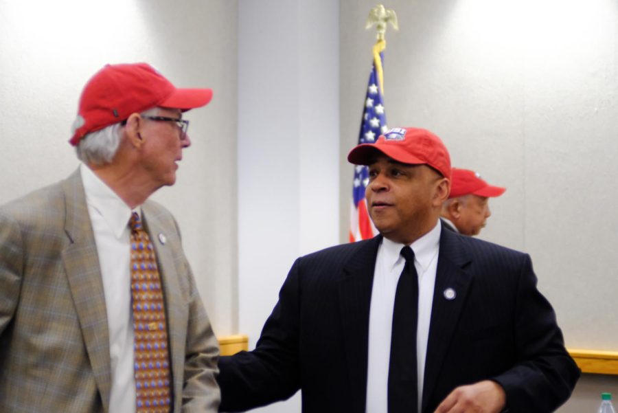 The Trustees and President Rochon pulled out red USI baseball caps from underneath the table after unanimously voting to transition to Division I.
