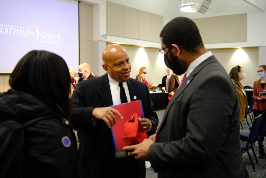 President Rochon hands his red USI cap to Rashad E. Smith, Executive Director for Enrollment, as a momento to the historic day.