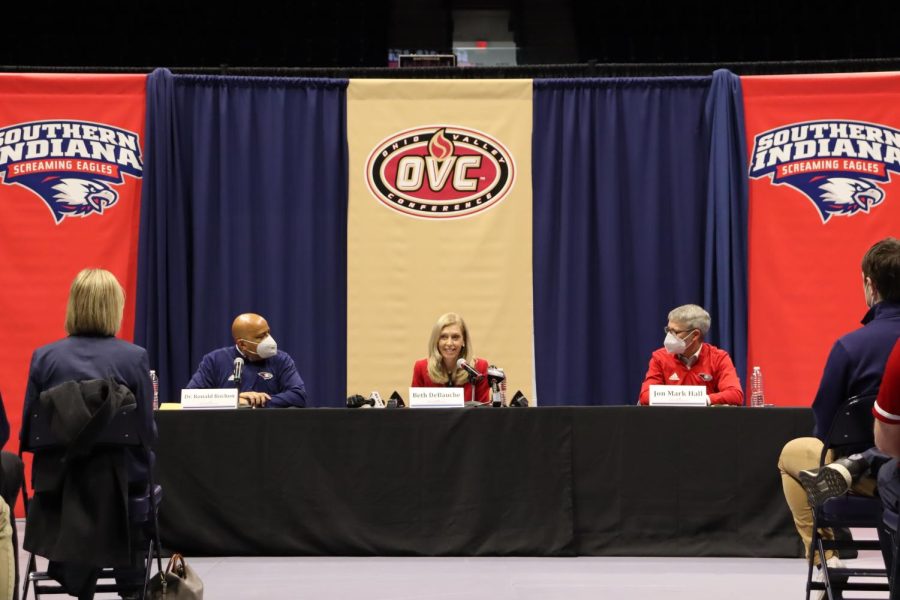 President Ronald Rochon (left) and Jon Mark Hall (right), university athletic director, listen as Beth DeBauche, Ohio Valley Commissioner, speaks at the press conference Wednesday. 