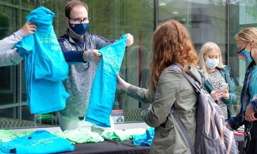 Nathan Payne,  the program coordinator for Center for Campus Life, passes out SpringFest 2020 T-shirts at SpringFest 2021. 
