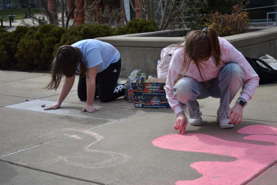 Lexi Rusk, sophomore health administration major, and Ava Hamilton, freshman nursing major, start on Gamma Beta Phis chalk mural.