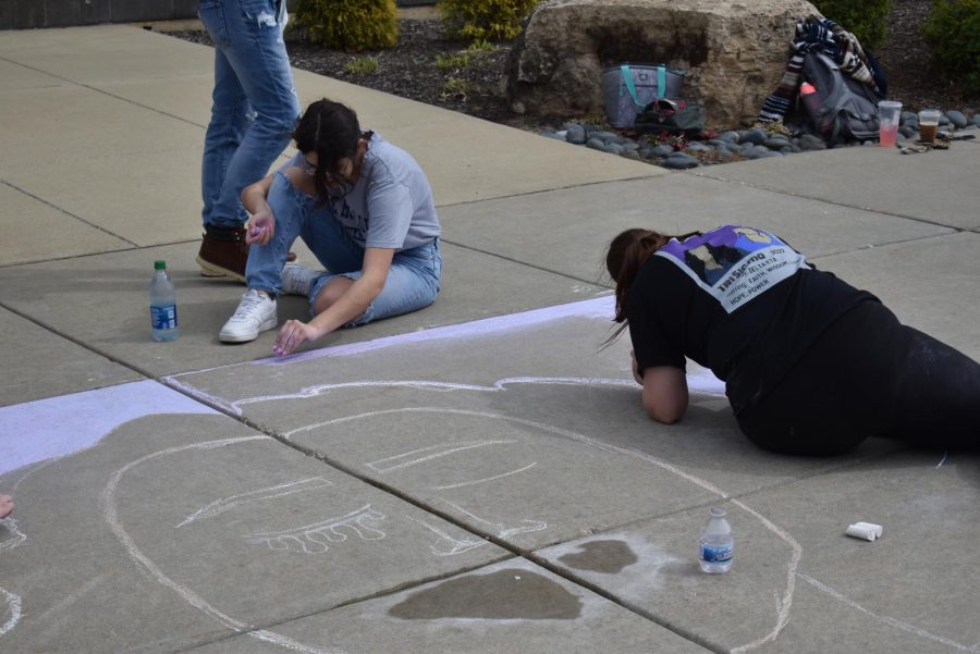 Annika Padgett, junior psychology and social work major, and Madelyne Newberry, freshman public relations major, work on the background of the mural for Sigma Sigma Sigma.