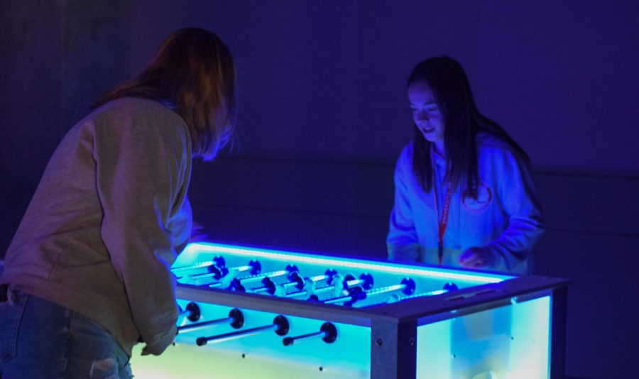 Students played foosball at the GloCade event at SpringFest 2022. GloCade also included light-up games like ping-pong, mini golf, giant jenga and darts.