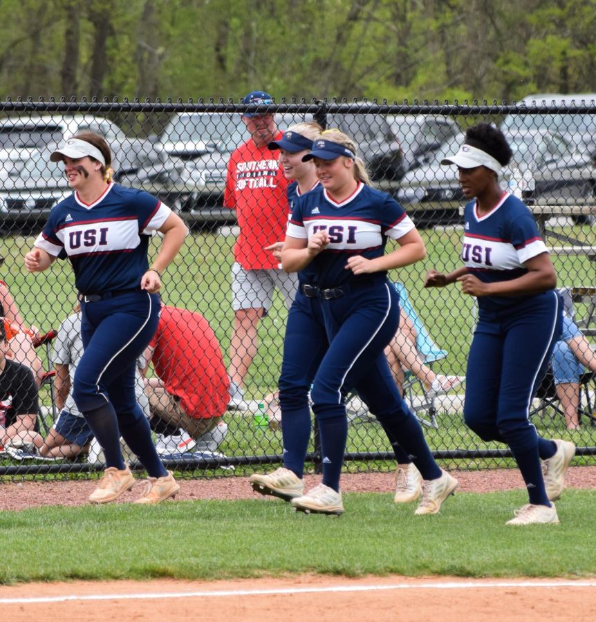 The womens softball team players run to the foul post before going out onto the field Sunday. The players made it a tradition to run between innings. 