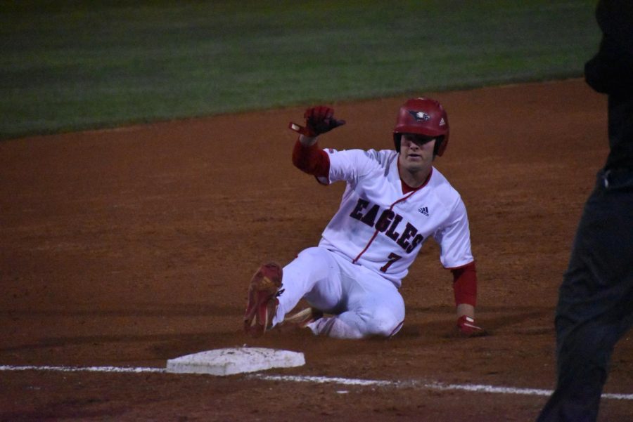 Trent Robinson, sophomore infielder and pitcher, slides into third base after hitting a triple to left field Thursday evening.