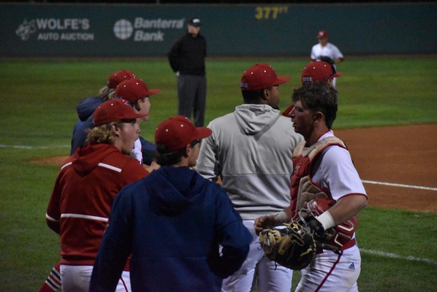 Members of the mens baseball team meet their teammates coming off the field after three quick outs in the bottom of the seventh inning Thursday evening.