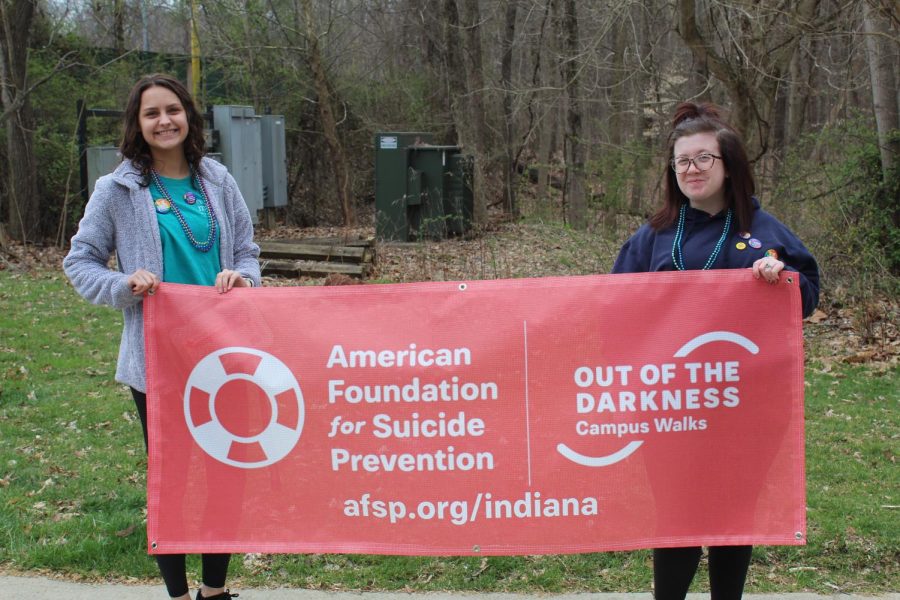 Madison Gerbig, junior biology major, and Brianna Aldana, junior geology major, pose with a banner displaying their cause before beginning the walk.