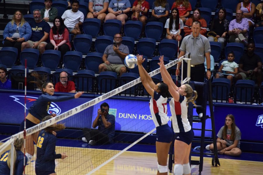 Bianca Anderson, freshman middle hitter, and Katherine Koch, junior outside hitter, right side hitter and setter, execute a block against Murray State Universitys volleyball team on Friday. USIs volleyball team performed 22 blocks during the game.