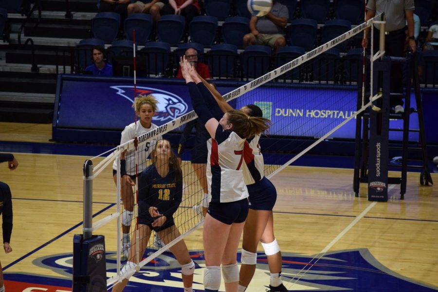 Leah Anderson, junior outside hitter, and Bianca Anderson, freshman middle hitter, reach high over the net for a block against Murray State University on Friday. Bianca had six blocks in total for the game.