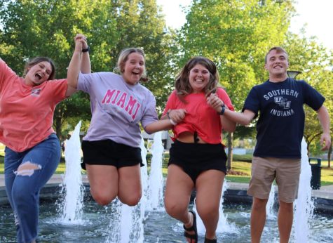(Left to Right) Maddy Shields, sophomore occupational therapy assistant and health administration major, Annie Tenbarge, freshman nursing major, Aubrey Ward, freshman pre-nursing major, and Marcus Robinson, sophomore pre-nursing major, jump together in front of the University Center Fountain. (Photo by Tegan Ruhl)