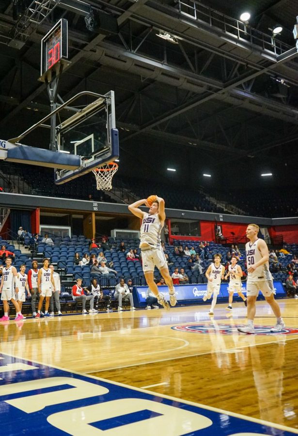 Jack Mielke, sophomore forward, broad jumps to dunk during warmups at the 2022 Midnight Madness event Thursday in the Screaming Eagles Arena.