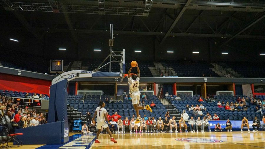 Kiyron Powell, freshman center, uses two hands on his second dunk attempt at the 2022 Midnight Madness event Thursday in the Screaming Eagles Arena. Isaiah Swope, junior guard, passed the ball off the edge of the backboard for Powell to catch.