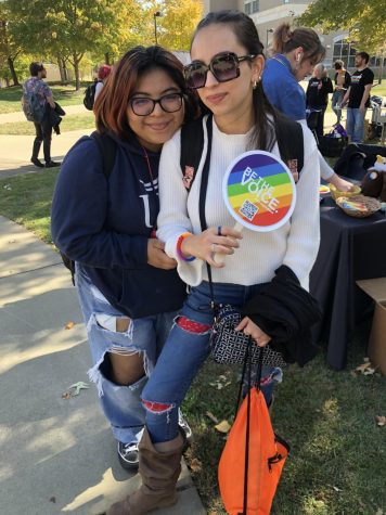 Toni Rodriguez, senior psychology major, and Alicia Cotton, sophomore political science major, smile near the Gender and Sexuality Resources table at PrideFest Friday. (Photo by Alyssa DeWig)