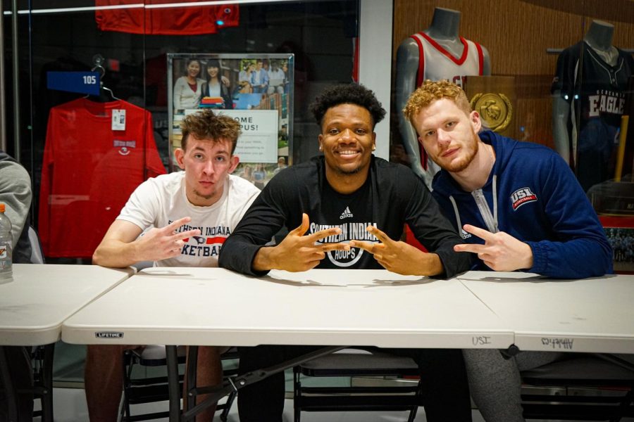 Jack Campion, freshman guard, Peter Nwoke, freshman forward, and Nick Hittle, sophomore forward, sign autographs during a meet-and-greet Friday in the Screaming Eagles Arena.
