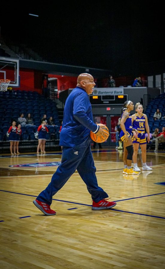 President Ronald Rochon steps on the court as an honorary referee for the tip off against Western Illinois University Friday in the Screaming Eagles Arena.