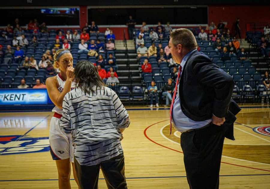 Head coach Rick Stein and Randa Gatling, assistant coach, talk to Hannah Haithcock, senior forward, during the free throws against Western Illinois University Friday in the Screaming Eagles Arena.
