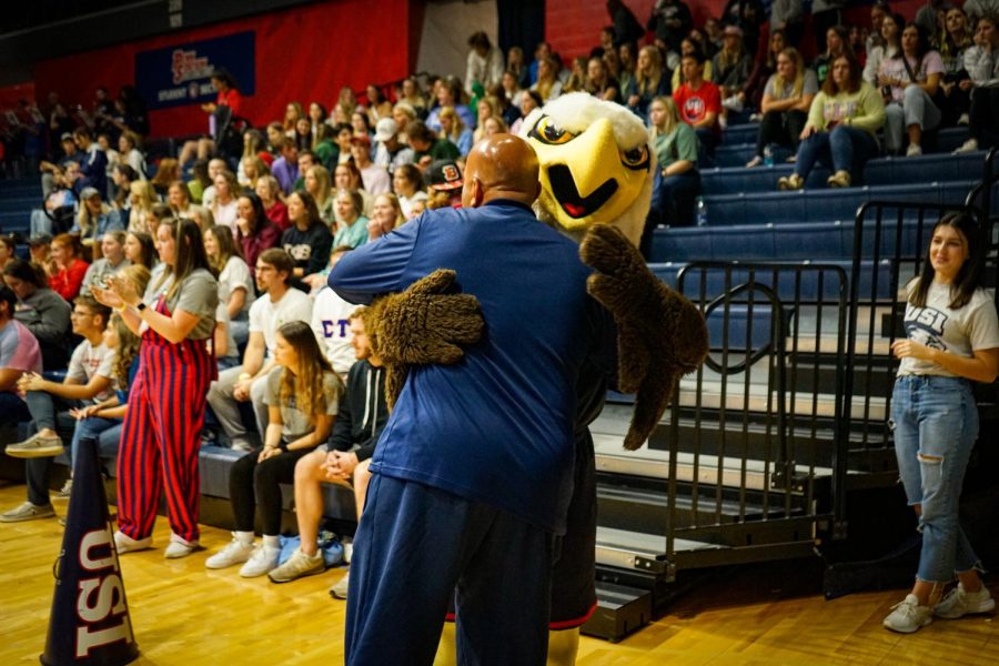 President Ronald Rochon embraces Archie the Eagle after the first half of the game against Western Illinois University Friday in the Screaming Eagles Arena.