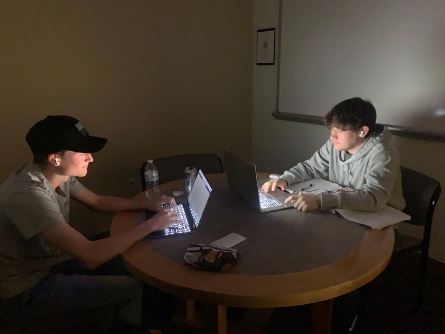 Preston Liebert, freshman electrical engineering major, and Gavin Davis, freshman computer science major, work on their laptops in a third-floor study room of the David L. Rice Library Monday afternoon during the power outage. (Photo by Bryce West)