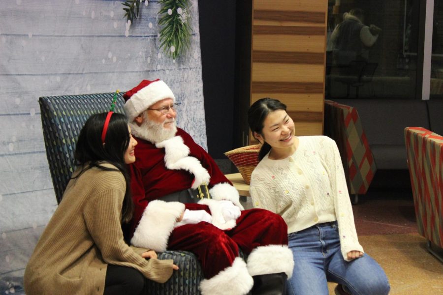 Students take photos with Santa Claus at the Lighting a Tradition Reimagined event in University Center East Friday. (Photo by Bryce West)