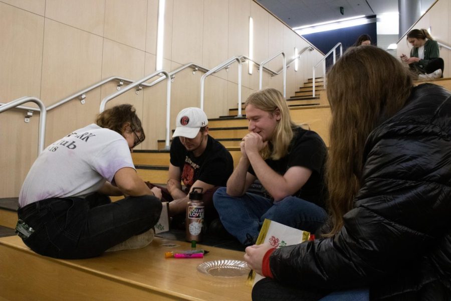 Violet Thomas-Cummings, junior art major, Luke Pettijohn, sophomore business administration major, Ben Settlemyer, senior civil engineering major, and Jaleigh Labrec, junior Spanish major, color their lanterns at the Lantern Let Go event in the Business and Engineering Center Tuesday. (Photo by Crystal Killian)