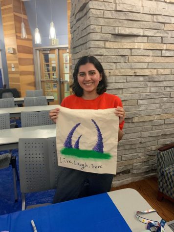 Karen Rivas, sophomore computer information systems major, smiles as she holds up her personalized tote bag Thursday at the Gamma Phi Omega International Sorority, Inc. informational meeting in the Traditions Lounge. (Photo by Anthony Rawley)