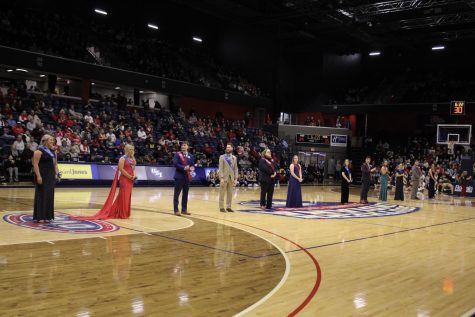 The 2023 Homecoming Court stands along the middle of the court during the Homecoming Ceremony Saturday in the Screaming Eagles Arena.