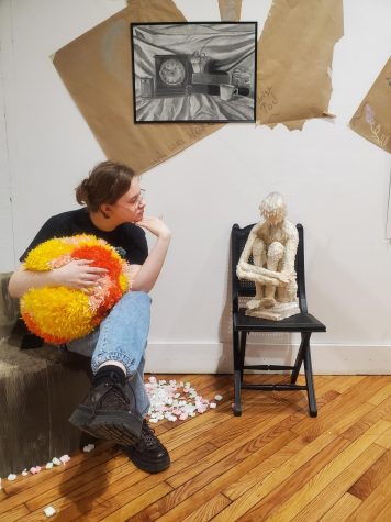 Al Sheets, senior art major, poses next to pieces in the Art Club's "Hodge Podge" collection Jan. 28 in the New Harmony Gallery of Contemporary Art. The gallery has been available for viewing in the NHGCA since Jan. 31 and will remain open through Feb. 25. (Photo courtesy of Tonya Lance)